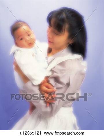 Stock Image - Mother with baby boy, portrait, front view, defocused. Fotosearch