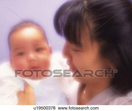 Stock Photo - Mother with baby boy, portrait, front view, defocused. Fotosearch