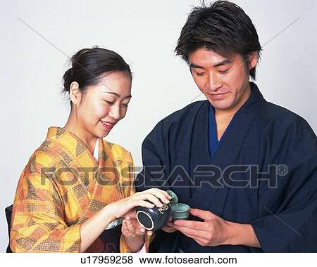 A couple in kimono serving and taking sake, Front View View Large Photo Image Stock Photo - A couple in kimono serving and taking sake, Front View. Fotosearch