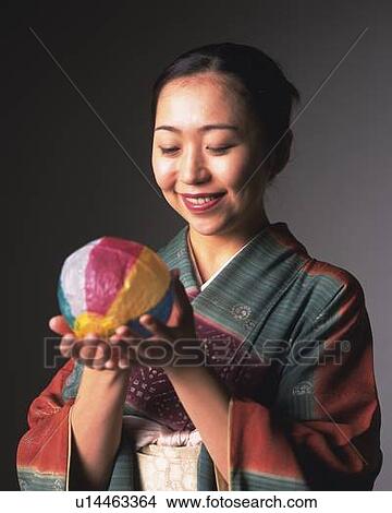 Picture - A woman in kimono playing with a Japanese Paper Baloon, Side View. Fotosearch