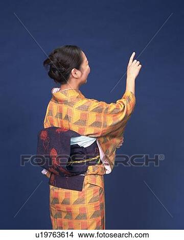 Picture - A woman in kimono pointing away, Rear View. Fotosearch