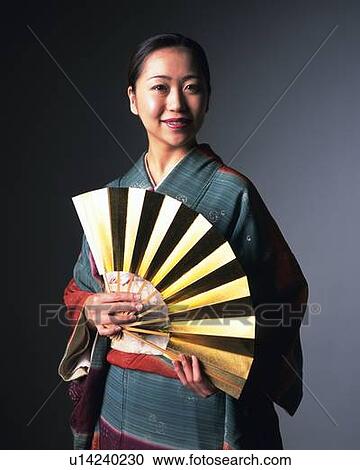 A woman in kimono smiling and holding a gold fan, Front View View Large Photo Image Stock Image - A woman in kimono smiling and holding a gold fan, Front View. Fotosearch