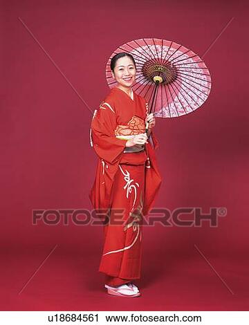 Stock Image - A woman in kimono smiling and holding a bangasa, Side View. Fotosearch