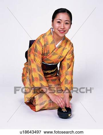 Stock Photo - A woman in kimono smiling and making Japanese Tea, Front View. Fotosearch