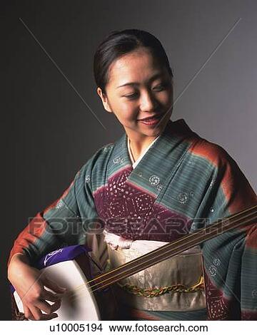 A woman in kimono smiling and playing shamisen, Front View View Large Photo Image Picture - A woman in kimono smiling and playing shamisen, Front View. Fotosearch
