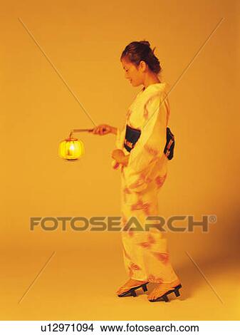 Picture - A woman in yukata holding a Japanese lantern, Side View, Toned Image. Fotosearch