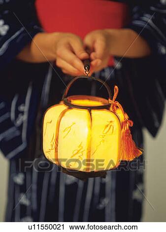Stock Image - A woman in yukata holding a Japanese lantern, Close Up, Differential Focus. Fotosearch