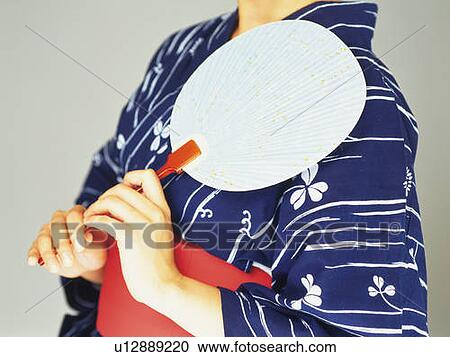 A woman in yukata holding a Japanese fan, Side View View Large Photo Image Stock Image - A woman in yukata holding a Japanese fan, Side View. Fotosearch