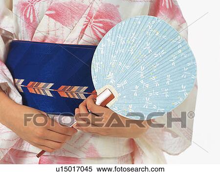 A woman in yukata holding a Japanese fan, Close Up View Large Photo Image Stock Photography - A woman in yukata holding a Japanese fan, Close Up. Fotosearch