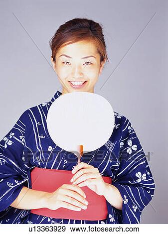 A woman in yukata smiling and holding a Japanese fan, Front View View Large Photo Image Stock Photo - A woman in yukata smiling and holding a Japanese fan, Front View. Fotosearch