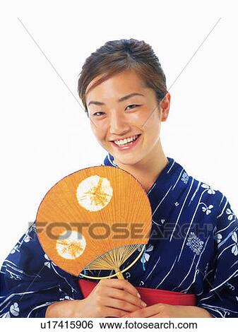 A woman in yukata smiling and holding a fan, Front View View Large Photo Image Stock Photograph - A woman in yukata smiling and holding a fan, Front View. Fotosearch