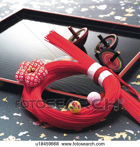 Stock Photo - Bunch of red strings and spinning tops on tray, high angle view. Fotosearch