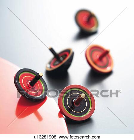 Stock Photo - Five spinning tops, high angle view, white background, differential focus. Fotosearch