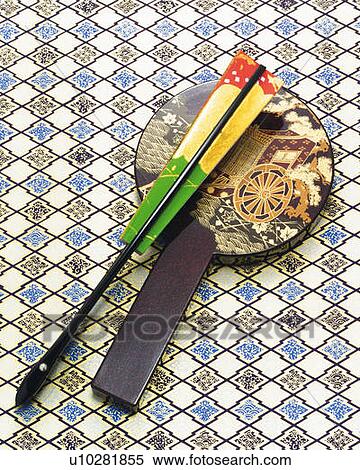 Stock Photography - Folded Japanese fan and hand mirror, high angle view. Fotosearch