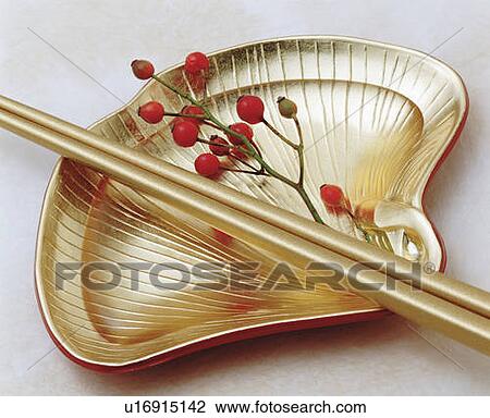 Gold chopsticks and red berries on shell-shaped gold plate, high angle view, white background View Large Photo Image Stock Image - Gold chopsticks and red berries on shell-shaped gold plate, high angle view, white background. Fotosearch