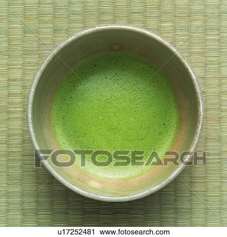 Stock Image - Japanese tea in bowl on Tatami mat, high angle view, Japan. Fotosearch