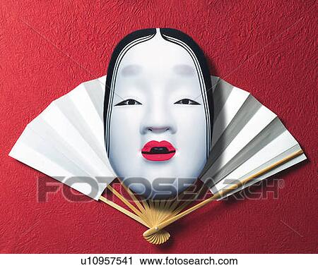 Stock Image - Noh mask on Japanese folding fan, front view, red background. Fotosearch