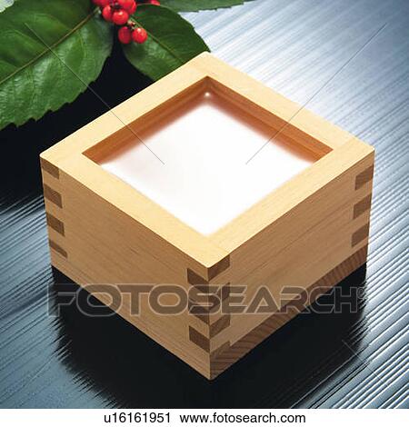 Stock Image - Sake in square wooden box, high angle view. Fotosearch