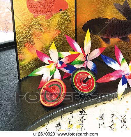 Stock Image - Spinning tops and shuttlecocks in front of gilded folding screen, high angle view. Fotosearch
