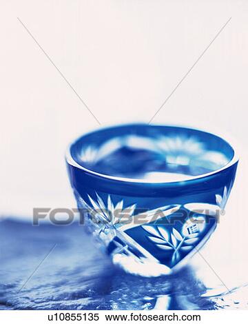Stock Photography - A glass of cold sake, high angle view, white background, differential focus. Fotosearch