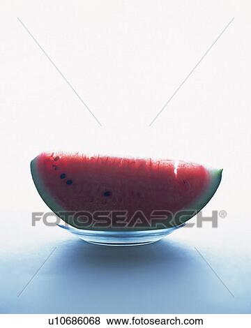 Stock Photo - A slice of watermelon on glass plate, front view, white background. Fotosearch