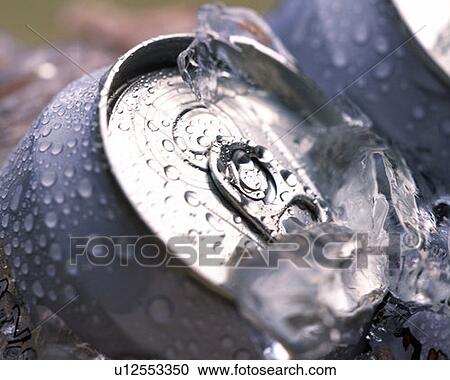 Stock Image - Cans of beer chilling with ice, high angle view, close up, differential focus. Fotosearch