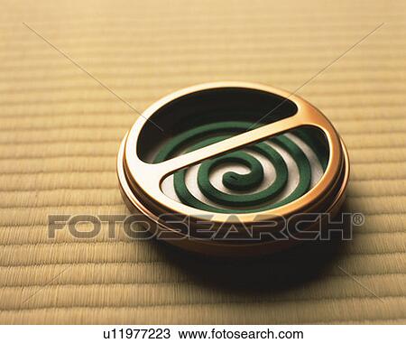 Stock Image - Coiled incense on Tatami mat, high angle view, Japan. Fotosearch