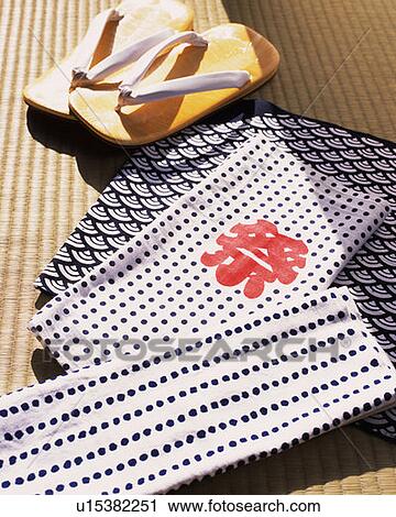 Stock Image - Japanese sandals and towels on Tatami mat, high angle view. Fotosearch