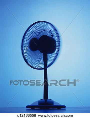 Stock Photo - Oscillating fan, rear view, toned image, blue background. Fotosearch