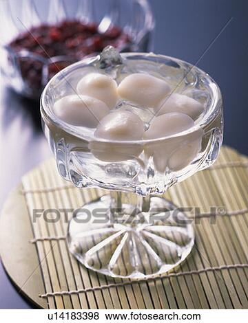 Stock Photo - Rice dumpling in cold water, high angle view, differential focus, blue background. Fotosearch