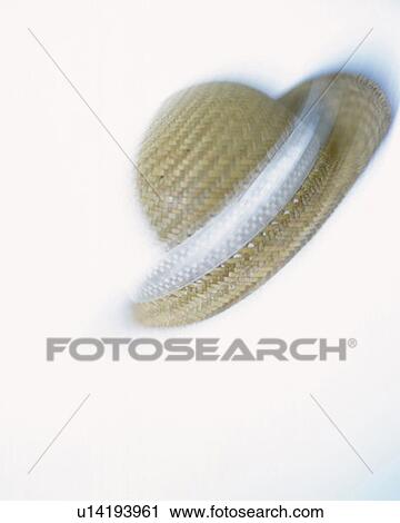 Stock Image - Straw hat, front view, white background, blurred motion, copy space. Fotosearch