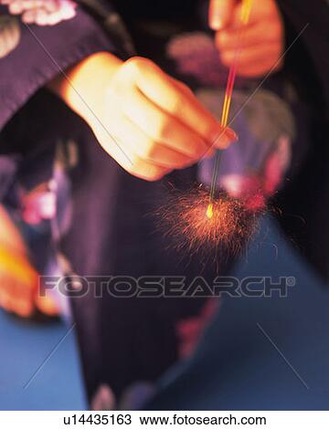 Woman in yukata holding a lighting firework, high angle view, blue background, differential focus View Large Photo Image Stock Image - Woman in yukata holding a lighting firework, high angle view, blue background, differential focus. Fotosearch