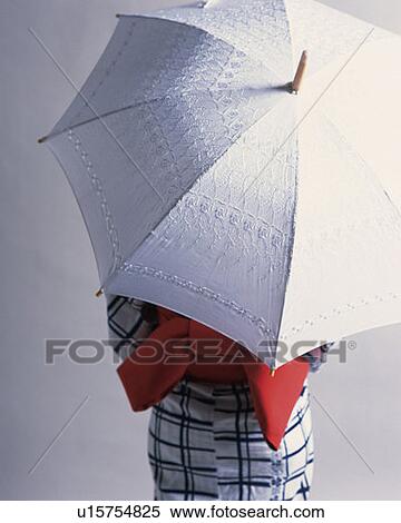Stock Photography - Woman in yukata holding parasol, rear view, white background. Fotosearch