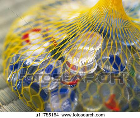 Picture - Bag of colorful flat marbles on Tatami mat, high angle view, close up, differential focus. Fotosearch