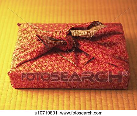 Stock Image - Gift wrapped in a cloth on Tatami mat, high angle view, differential focus. Fotosearch