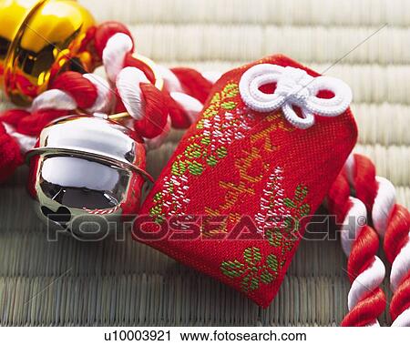 Stock Image - Japanese amulet and gold and silver bells put on strap, high angle view. Fotosearch