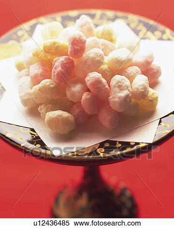 Stock Photography - Japanese cubic rice crackers on plate, high angle view, differential focus, red background. Fotosearch
