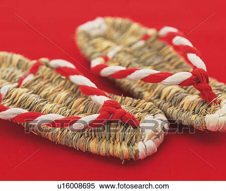 Stock Photography - Japanese straw sandals, high angle view, red background, differential focus. Fotosearch