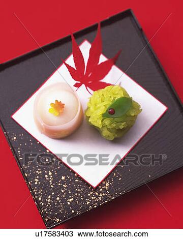 Stock Image - Japanese sweets on plate, high angle view, red background. Fotosearch
