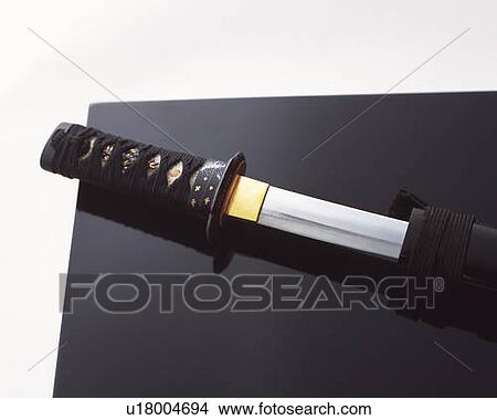 Picture - Japanese sword on black surface, high angle view, white background. Fotosearch