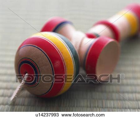 Stock Image - Japanese toy (Kendama) on Tatami mat, high angle view, differential focus. Fotosearch