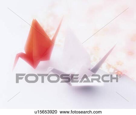 Stock Image - Red and white Origami birds, high angle view, white background, soft focus. Fotosearch