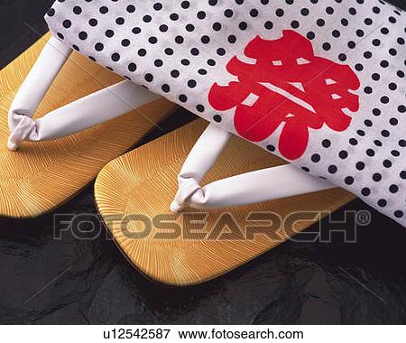 Stock Photo - Towel on Japanese sandals, high angle view, black background. Fotosearch