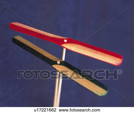 Stock Image - Two bamboo-copters, high angle view, blue background, differential focus. Fotosearch