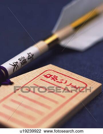 Stock Image - Wooden plaque and arrow, high angle view, blue background, differential focus. Fotosearch