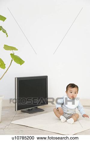 Stock Image - Baby Sitting In Front of Television. Fotosearch