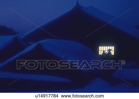 Picture - Roofs are covered with snow and human silhouette. Fotosearch