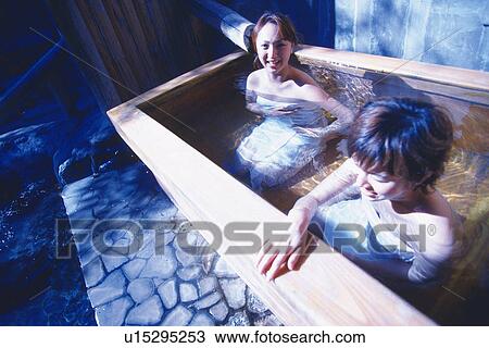 Stock Image - Two Young Adult Women Taking a Bath. Fotosearch