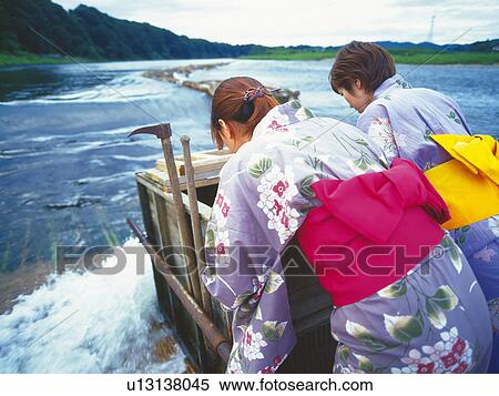 Stock Photography - Two Young Adult Womon Standing at Weir. Fotosearch