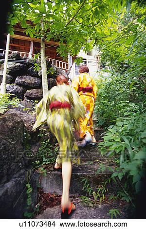 Picture - Two Young Woman Walking Up Staircase. Fotosearch